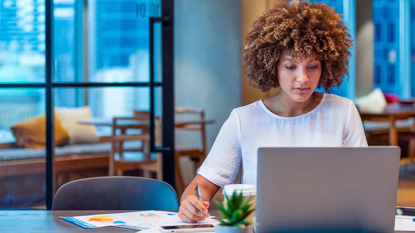Donna al computer che prende appunti